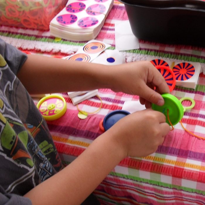 Hands threading the string through a Yop-Yop